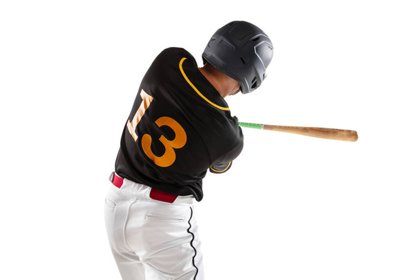 Baseball player, pitcher in a black white sports uniform practicing isolated on a white studio background. Back view - Foto, Imagen