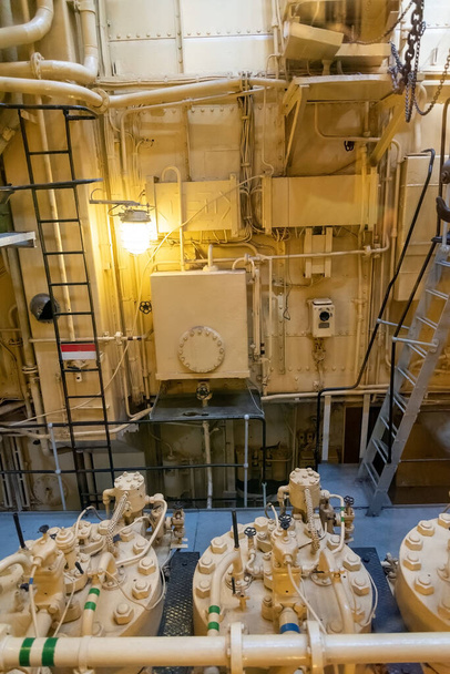 船に搭載された黄色いエンジン。古い貨物船のエンジンルーム。機関室内の大型エンジン. - 写真・画像