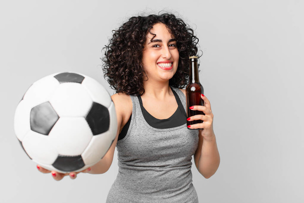 pretty arab woman with a soccer ball and having a beer - 写真・画像