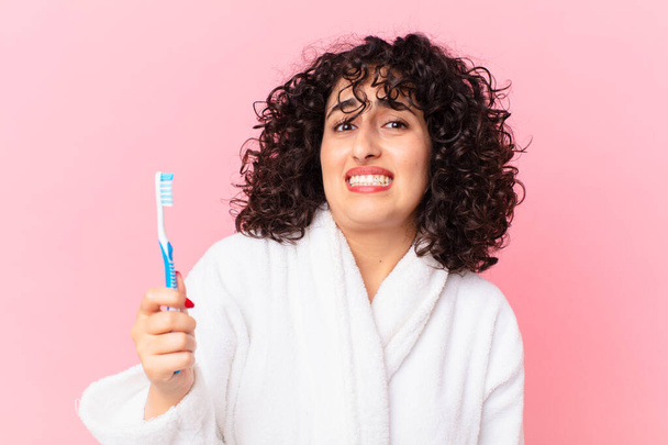 pretty arab woman wearing bathrobe and using a teeth brush - 写真・画像