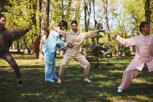 Tai chi instructor correcting stance of female student - 写真・画像
