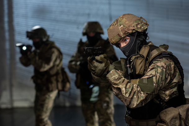 Військовослужбовці зі зброєю наближаються після злочинця
 - Фото, зображення