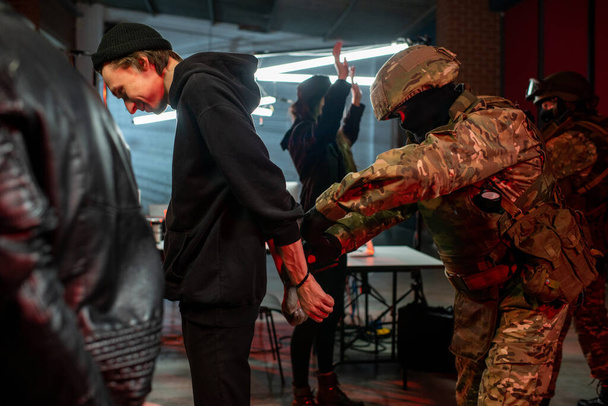 Officier in camouflage outfit vangt groep hackers - Foto, afbeelding