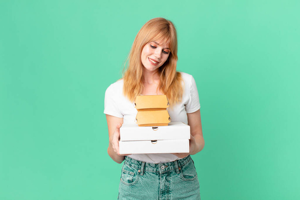 pretty red head woman holding fast food take away boxes - Foto, Imagen