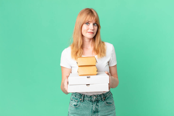 pretty red head woman holding fast food take away boxes - Foto, imagen