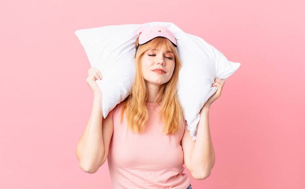 pretty red head woman wearing pajamas and holding a pillow - Photo, image
