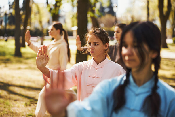 Females pushing arm forward with open palm during tai chi - Foto, Bild