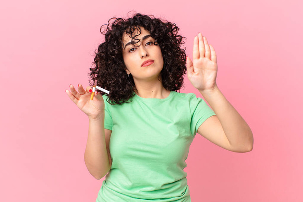 pěkná arabka, která vážně ukazuje otevřenou dlaň, aby zastavila gesto. zákaz kouření - Fotografie, Obrázek