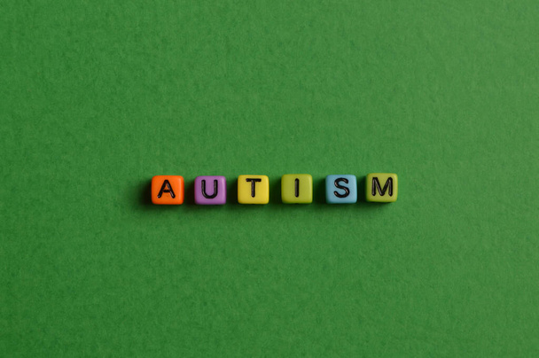 Alphabet letters with text AUTISM isolated on green background - Фото, зображення