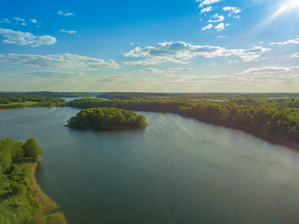 ドローンで湖の上に美しい空中風景。晴れた日には森や畑に覆われた多くの湖の島 - 写真・画像