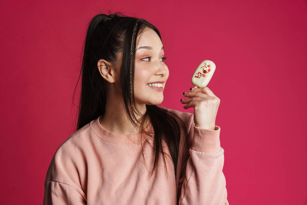 Asian brunette happy woman smiling while holding ice cream isolated over purple wall - Φωτογραφία, εικόνα