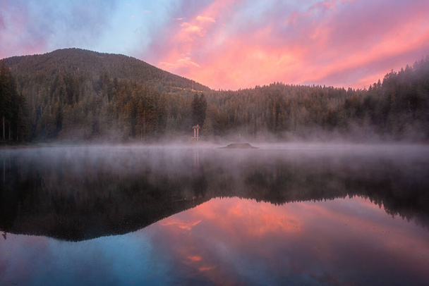 Tüzes napkelte az alpesi tó Synevyr, Kárpátok, csodálatos természet táj reggeli köd, erdő, színes ég és tükröződés a vízben, szabadtéri utazási háttér, Zakarpattia, Ukrajna - Fotó, kép