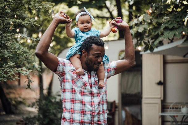 Happy father holding cute daughter in summer park. Happy parenthood concept  - Fotoğraf, Görsel