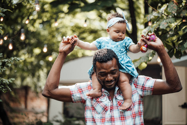 Happy father holding cute daughter in summer park. Happy parenthood concept  - Fotó, kép