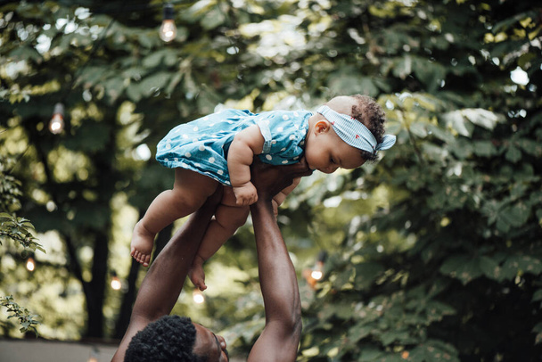 Счастливый отец держит милую дочь в летнем парке. Концепция счастливого родительства  - Фото, изображение