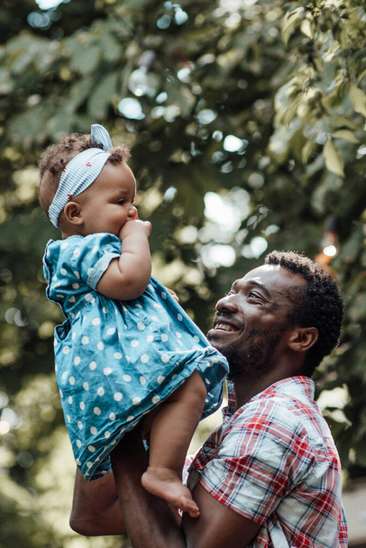 Happy father holding cute daughter in summer park. Happy parenthood concept  - Foto, afbeelding