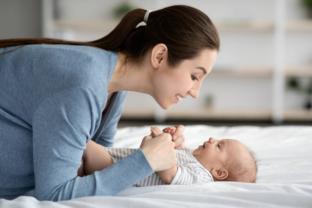 Conexión madre-hijo. Feliz amor joven mamá vinculación con el recién nacido en casa - Foto, Imagen
