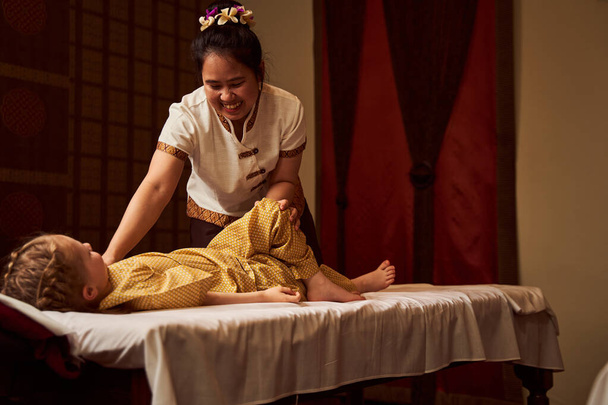 Therapist in uniform doing massage to kid - Foto, Bild