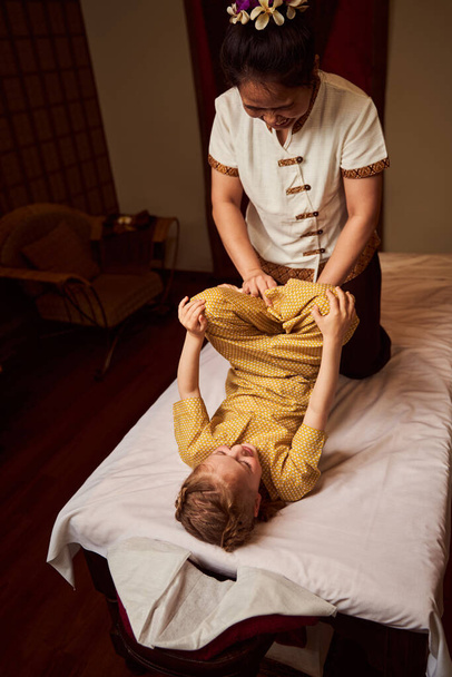 Experienced therapist training flexibility body of kid - Foto, afbeelding
