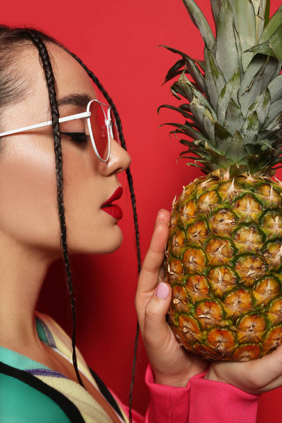 Mladá žena s čerstvým ananasem na červeném pozadí. Exotické ovoce - Fotografie, Obrázek