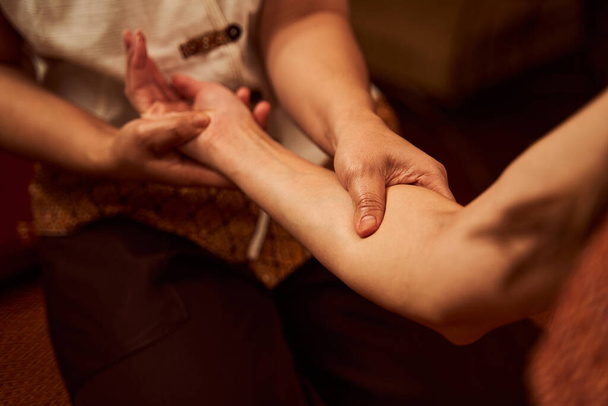 Masseur giving massage to client in cozy salon - Foto, imagen