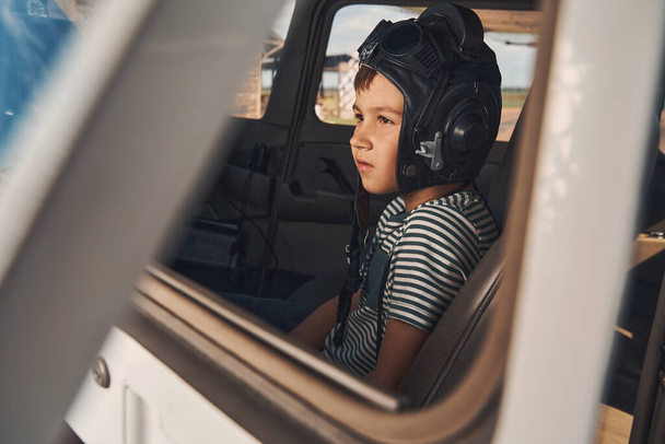 Niedlicher Junge Pilot sitzt im Flugzeug-Cockpit - Foto, Bild