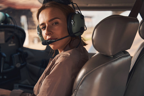 Beautiful young woman sitting inside plane cockpit - Φωτογραφία, εικόνα
