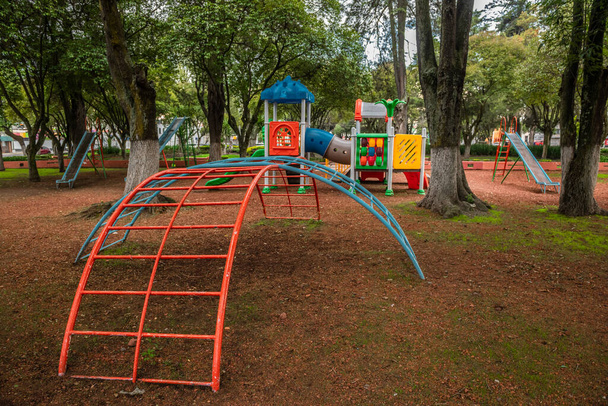 野外公園の遊び場には、スライド、スイング、城、ゲームが公園の自然のトーンと対照的な多くの色があります。. - 写真・画像