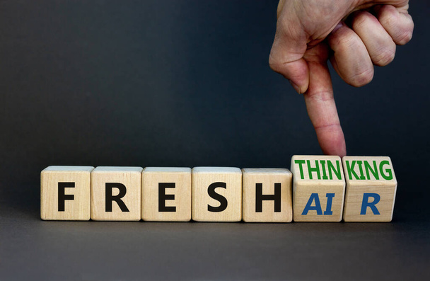 Fresh thinking and air symbol. Businessman turns wooden cubes, changes words fresh thinking to fresh air. Beautiful grey background. Copy space. Business, ecological, fresh thinking and air concept. - 写真・画像