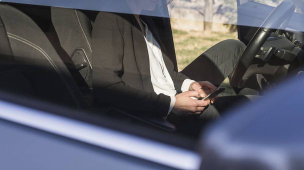 Podnikatelka pomocí telefonu sedí v autě - Fotografie, Obrázek