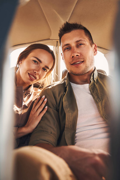 Beautiful young couple in love sitting in vehicle - Foto, afbeelding
