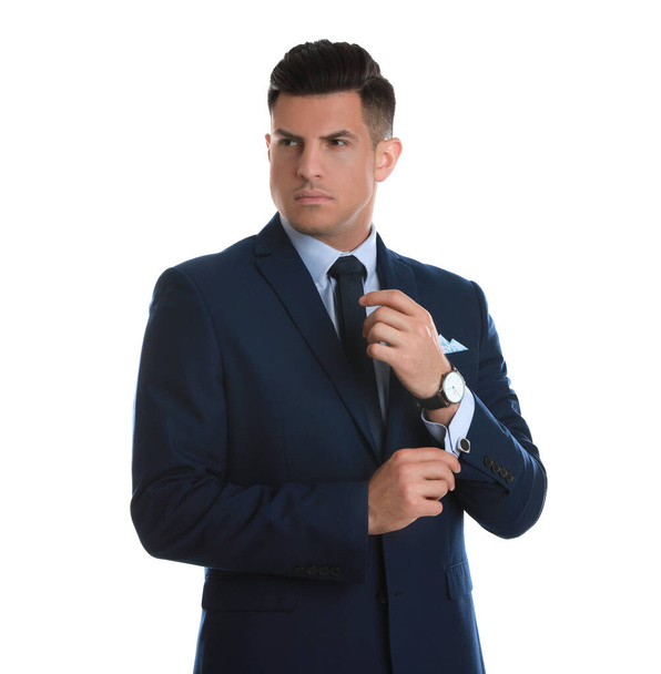Handsome stylish man putting on cufflink against white background - Photo, Image