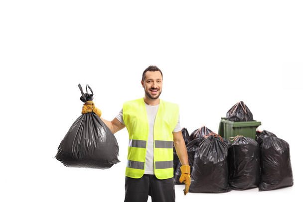 Colector de residuos que sostiene una bolsa de plástico negro aislada sobre fondo blanco - Foto, Imagen