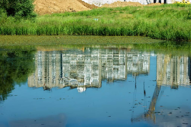 Reflexion von mehrstöckigen Gebäuden im Teich, im Sommer - Foto, Bild