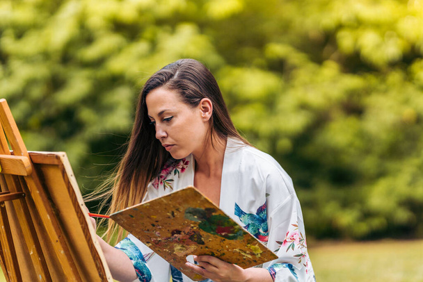 Mujer pintando sobre lienzo al aire libre - Foto, Imagen