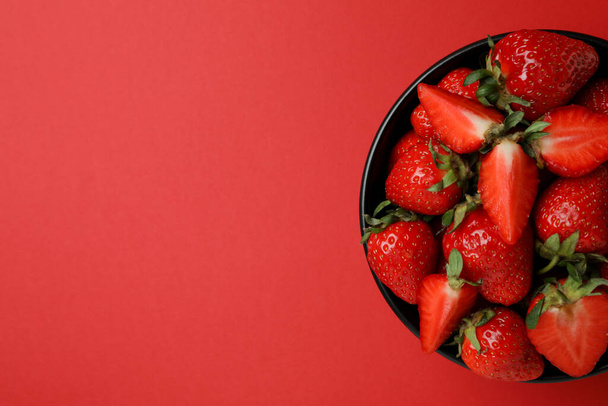 Bol de fraise fraîche sur fond rouge - Photo, image
