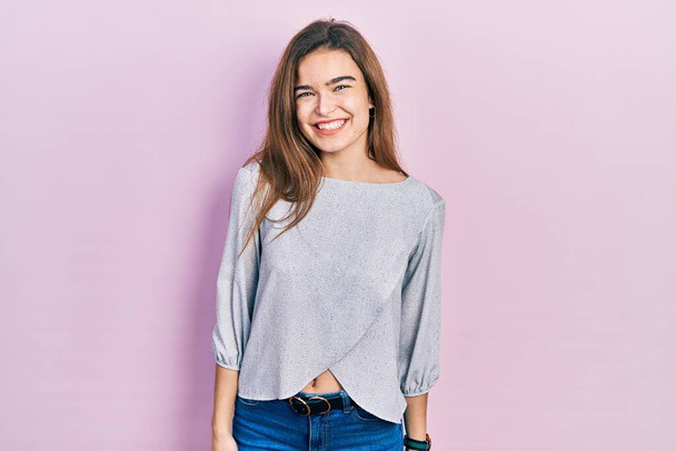 Fiatal kaukázusi lány visel alkalmi ruhák pozitív és boldog álló és mosolygó magabiztos mosollyal mutatja fogak  - Fotó, kép