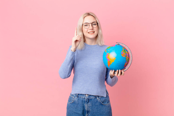blond pretty woman holding a worl globe map - 写真・画像