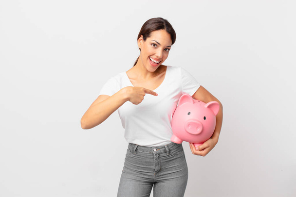 young hispanic woman with a piggy bank - Foto, afbeelding