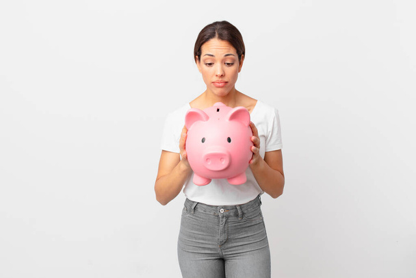 young hispanic woman with a piggy bank - Photo, image