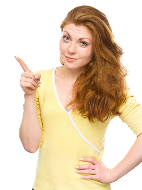 Portrait of a young woman pointing to the right - Photo, image
