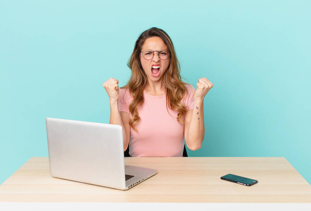 pretty woman shouting aggressively with an angry expression. telework concept - Foto, imagen