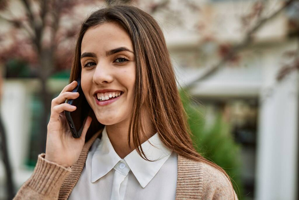 Jeune femme d'affaires hispanique souriant heureux de parler sur le smartphone de la ville. - Photo, image