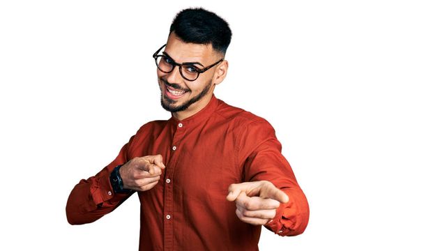 Young hispanic man with beard wearing business shirt and glasses pointing fingers to camera with happy and funny face. good energy and vibes.  - Photo, Image