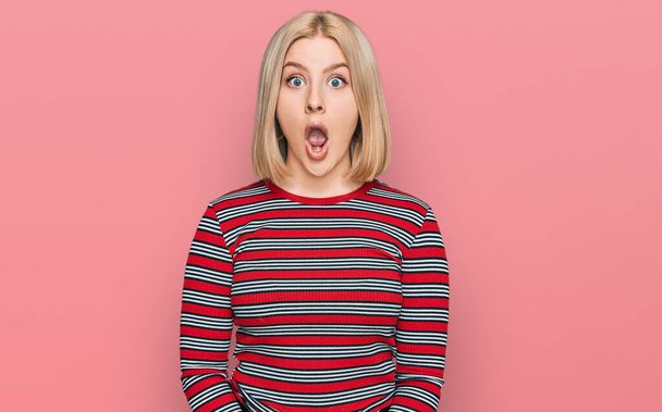 Young blonde woman wearing casual clothes afraid and shocked with surprise expression, fear and excited face.  - 写真・画像
