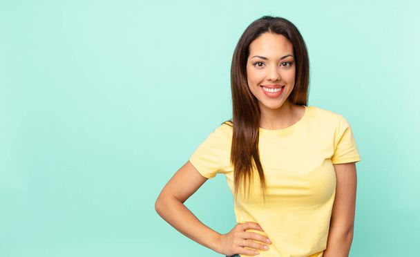 young hispanic woman smiling happily with a hand on hip and confident - Photo, Image