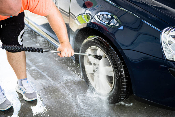 Πλυντήριο και καθαρισμός αυτοκινήτων σε αυτο-υπηρεσία πλυντηρίου αυτοκινήτων σταθμό. Πλύσιμο αυτοκινήτου με νερό υψηλής πίεσης στο Βουκουρέστι, Ρουμανία, 2021 - Φωτογραφία, εικόνα