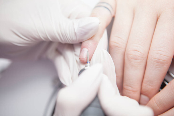 Cropped close up of manicurist using nail drill on cuticles of client - Foto, Imagem