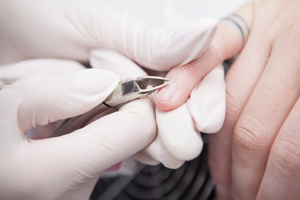 Close up of  female client having cuticles removed with nippers by her manicurist - Foto, afbeelding