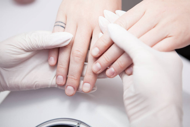 Close up of manicurist examining nails of client - Foto, Bild